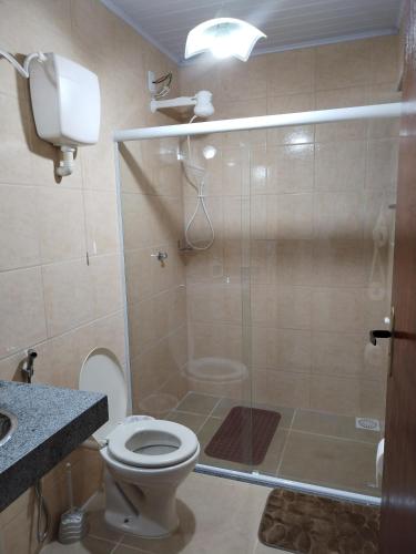 a bathroom with a shower with a toilet and a sink at Casa Zago 2 in Santa Maria Madalena