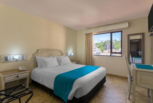 a hotel room with a bed and a window at Hotel Obelisco in Cali