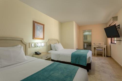 a hotel room with two beds and a television at Hotel Obelisco in Cali
