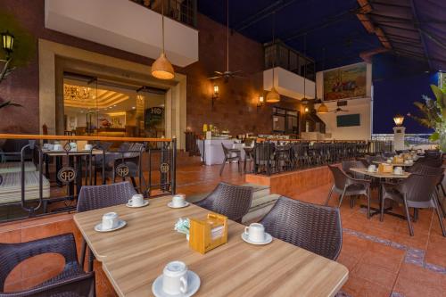 a restaurant with tables and chairs and a bar at Hotel Obelisco in Cali