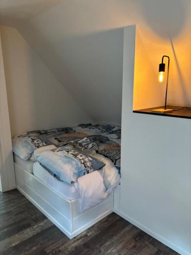 a small bed in a room with a lamp at Bij Hilma in Eext