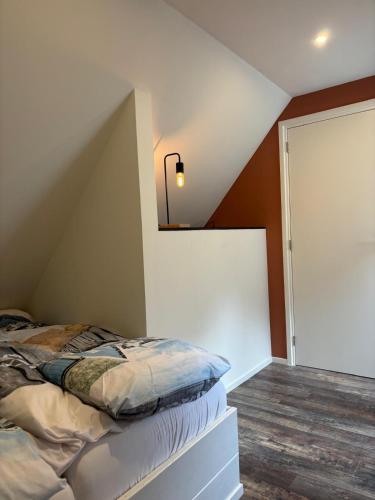a bedroom with a bed and a mirror on the wall at Bij Hilma in Eext