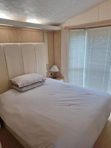 a large white bed in a room with a window at Wonderful views in Startforth