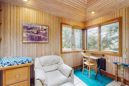a room with a chair and a desk and windows at Cypress Cove in Sea Ranch