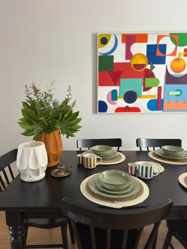 a black dining room table with chairs and a painting at Menina da Ria Guest House in Aveiro