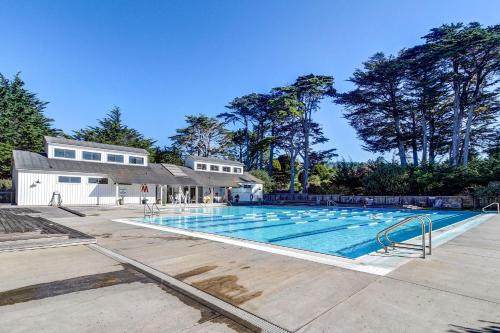 an empty swimming pool in front of a house at Cypress Cove in Sea Ranch