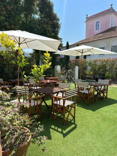 a group of tables and chairs with umbrellas at Menina da Ria Guest House in Aveiro