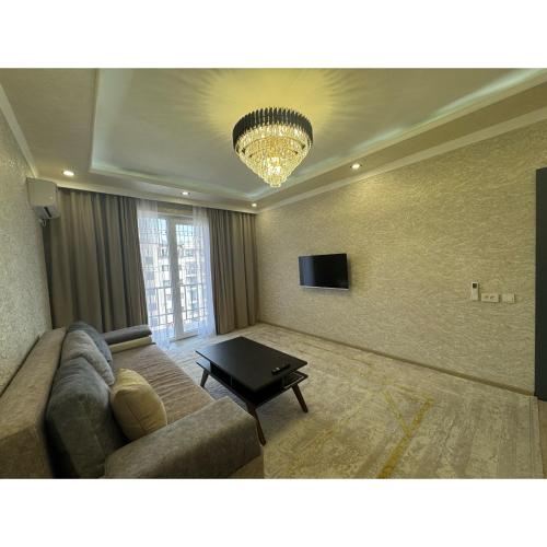 un soggiorno con un divano e un tavolo di Cozy Classic Apartment a Tashkent