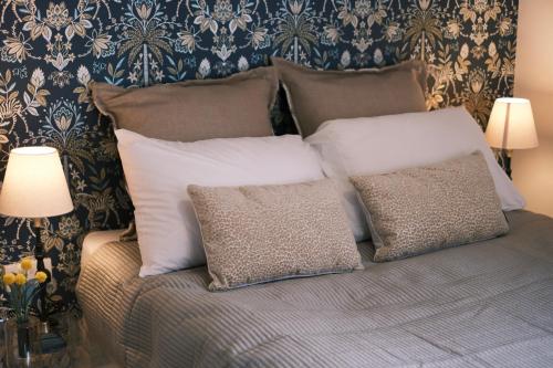 a bed with white pillows and a blue and gold wallpaper at Oxford Nest - Spacious & Luxury Apartments in Oxford