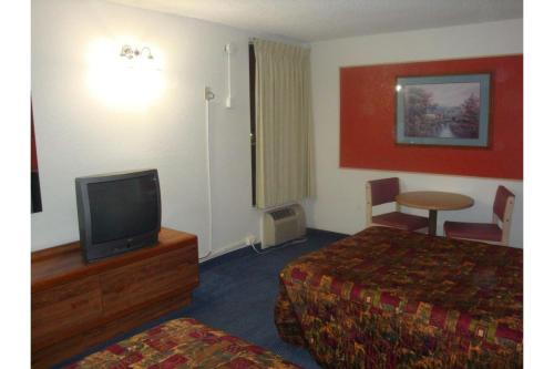 a hotel room with a bed and a television at Travelers Inn by Hotel O Lake Havasu City in Lake Havasu City