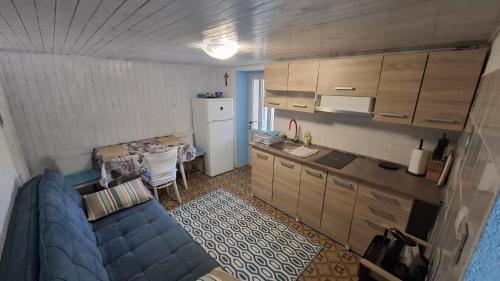 a living room with a blue couch and a kitchen at Guesthouse Pijerino in Valun