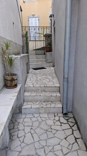 a stone walkway with stairs and potted plants at Guesthouse Pijerino in Valun