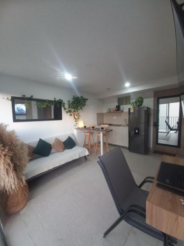 ein Wohnzimmer mit Couch und Küche in der Unterkunft Apartamento en santa marta con picsina vía tayrona y palomino in Santa Marta