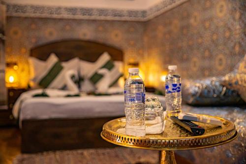 a table with two bottles of water on top of a bed at Riad Hikaya - Fes Story in Fès
