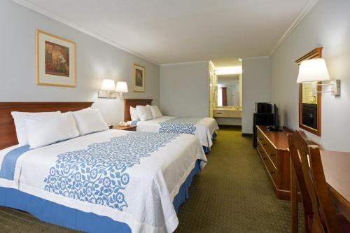 Cette chambre comprend deux lits et une télévision. dans l'établissement Days Inn by Wyndham Clinton, à Clinton