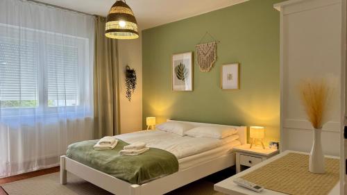 a small bedroom with a bed and a window at City Center & Free Parking - Rest & Nest Boho Deluxe Apartment in Debrecen