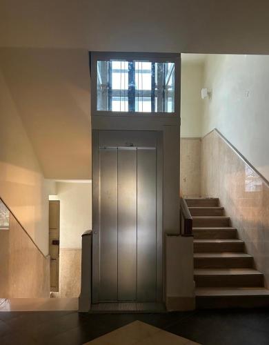 a hallway with stairs and a large door in a building at M&M’s Home in Terni