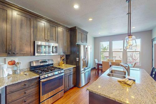 a kitchen with wooden cabinets and a stove top oven at Happy Tails Hideout in Kamas