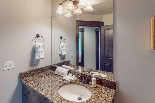 a bathroom with a sink and a large mirror at Happy Tails Hideout in Kamas