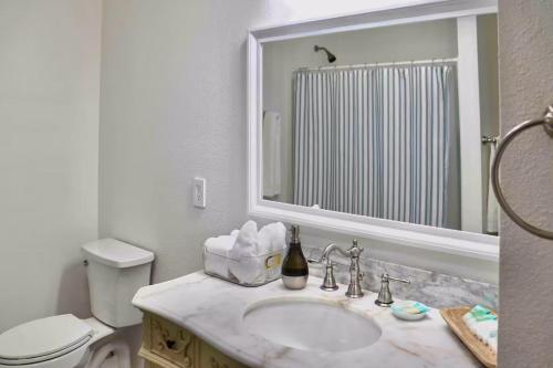 ein Badezimmer mit Waschbecken, Toilette und Spiegel in der Unterkunft Regal Redwoods in Fort Bragg