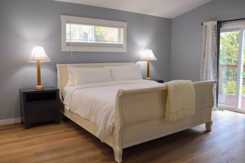 ein Schlafzimmer mit einem Bett und zwei Lampen und einem Fenster in der Unterkunft Regal Redwoods in Fort Bragg