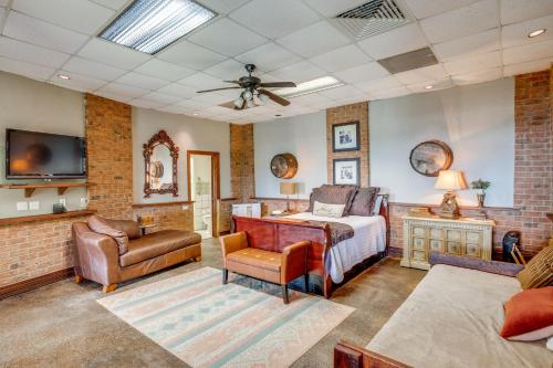 a bedroom with a bed and a couch and a tv at 1 Mi to Lake Guntersville Scenic Condo Retreat! in Scottsboro