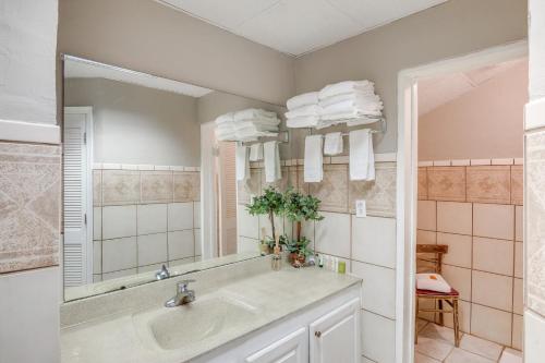 a bathroom with a sink and a mirror at 1 Mi to Lake Guntersville Scenic Condo Retreat! in Scottsboro