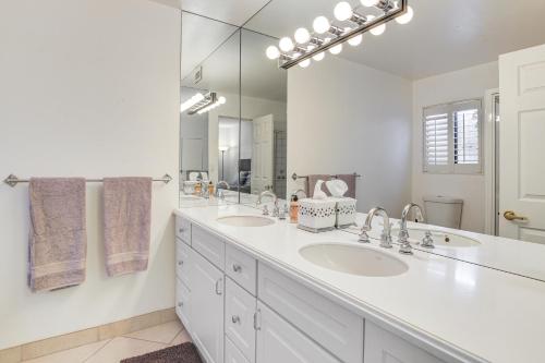 a white bathroom with two sinks and a large mirror at Palm Desert Condo with Community Perks WFH Friendly in Palm Desert