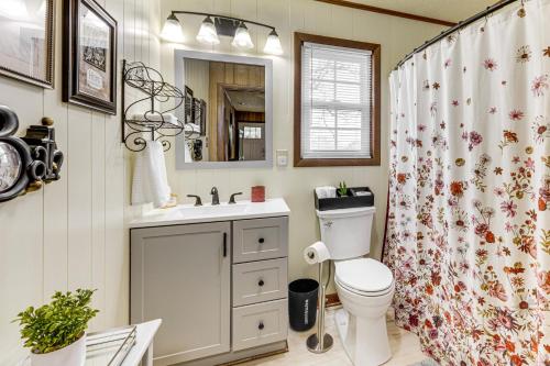a bathroom with a toilet and a sink and a shower curtain at Scenic East Alabama Retreat on 2 Acres in Lineville