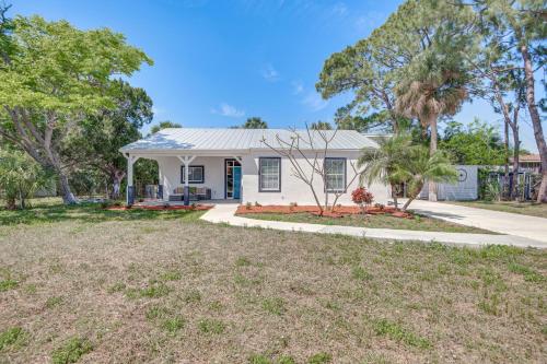 a white house with palm trees and a driveway at Fishing Paradise Lake Poinsett Home with Deck! in Cocoa