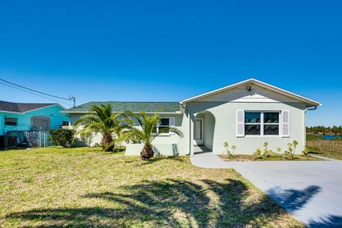 a white house with palm trees in the yard at 2 Mi to Beach Canal-Front Home in Hernando Beach in Hernando Beach