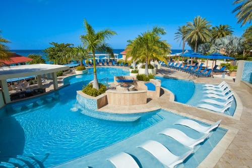 an infinity pool at a resort with palm trees at Divi Little Bay Beach Resort in Philipsburg