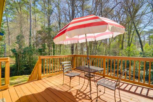 a patio with an umbrella and chairs on a deck at 6 Mi to Stone Mtn Park The Forrest Home with Deck in Snellville