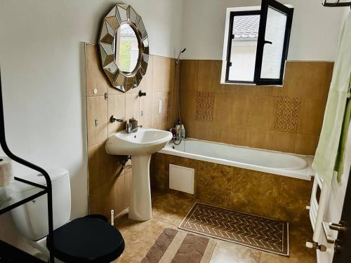 a bathroom with a sink and a tub and a mirror at Private Room in Voluntari Quiet & Cozy Stay in Voluntari