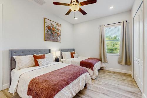 2 letti in una camera da letto con ventilatore a soffitto di Sea Clarity a Port Charlotte