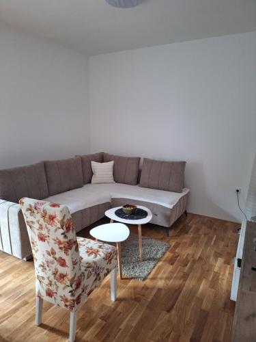 a living room with a couch and a table and a chair at Apartman ZID in Smederevska Palanka