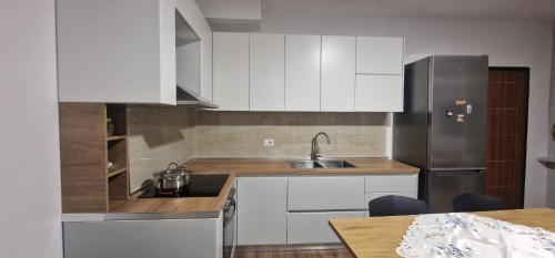 a kitchen with white cabinets and a stainless steel refrigerator at Comfortable holiday apartament in Golem