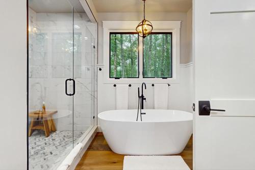 Una bañera blanca en un baño con ventana. en The Fox Den, en Cashiers