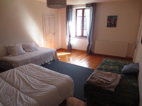 a living room with two beds and a couch at Gite Les Arrebourits 4 étoiles in Anères