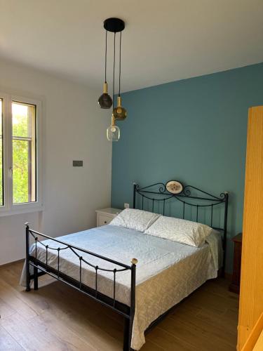 a bedroom with a bed and a blue wall at Oasibellavista in Cavo