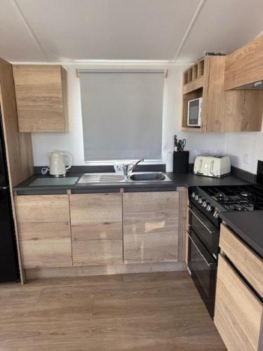 a small kitchen with a sink and a stove at Modern 8 Berth Caravan With Near To Scratby Beach At Cali Cliffs Ref 50010Ae in Great Yarmouth