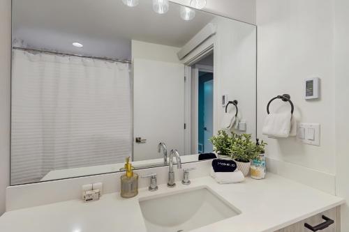 a bathroom with a sink and a large mirror at Rainier Valley Retreat in Seattle