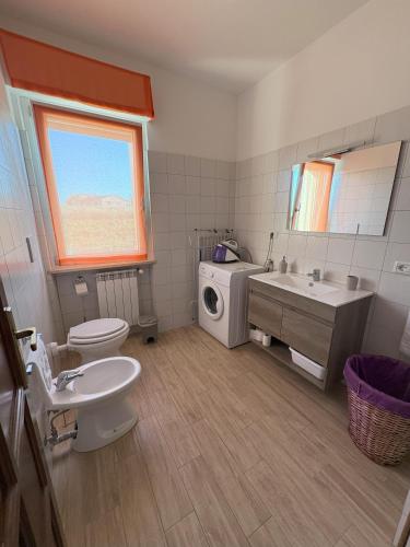 a bathroom with a sink toilet and a washing machine at La casa di Nana' 1 in Casalbordino