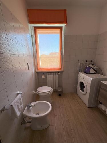 a bathroom with a toilet and a washing machine at La casa di Nana' 1 in Casalbordino