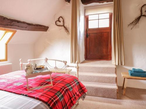 - une chambre avec un lit et une couverture rouge dans l'établissement Cyffdy Cottage - Tegid, à Bala