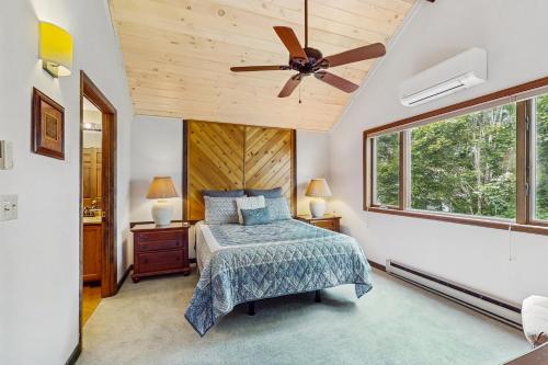 Un dormitorio con una cama y un ventilador de techo. en Skyleaf 404, en Sugar Mountain