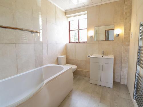 une salle de bain avec une baignoire, des toilettes et un lavabo dans l'établissement Cyffdy Cottage - Arenig, à Bala