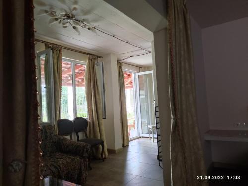 a living room with a ceiling fan and a mirror at Gusthouse Shekvetili AE in Shekvetili