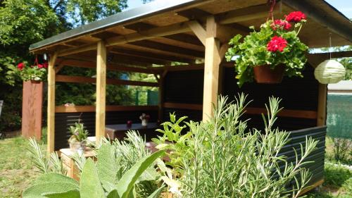 a wooden pergola with flowers in a garden at Pension im Gesundbrunnental in Bad Freienwalde