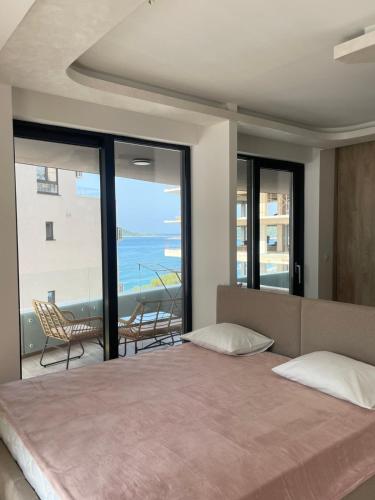 a bedroom with a bed and a view of the ocean at Green Stone lamela B in Rafailovici
